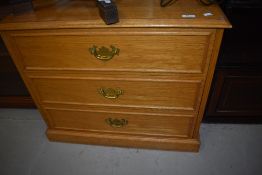 A modern golden oak effect three drawer bedroom chest