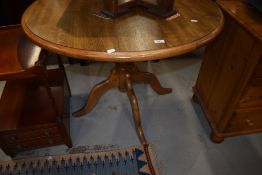 A modern circular dining table on quadruple splay legs