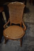 A late Victorian low nursing style rocking chair having a restored bergere woven back and seat