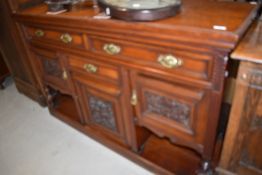 A Victorian mahogany sideboard base having brass drop handles and carved panels