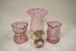 A vintage vase having pink hue and fluted rim, an art glass jug, and two etched jugs having pink
