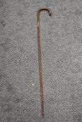 An antique textured wood walking cane having silver cuff to shaft and silver pips to handle.