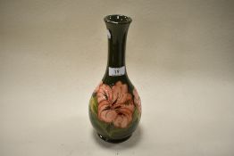 A 1982 dated Moorcroft pottery vase of elongated baluster form, having green ground with tube