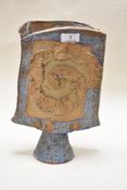 A Studio pottery vase, of abstract spade shape having unglazed clay finish accented with blue slip.