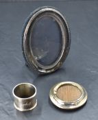 An modern oval silver photograph with black velvet easel back, a small circular silver photo frame