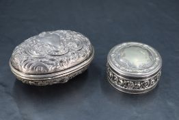 An Edwardian silver box, of hinged oval form embossed throughout with foliate and C-scrolls