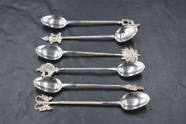 A group of six Eastern white metal spoons, each having twisted stems and differing terminals,
