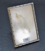 An Indian white metal photograph frame, of rectangular form with rope-twist type decoration,