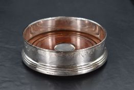 An Elizabeth II silver wine coaster, of typical form and decorated with foliate scrolls, marks for