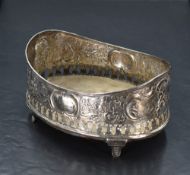 A 19th century white metal coaster, of oval form form with moulded rim and profuse embossed