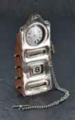 An Edwardian silver mounted rolling desk calendar/watch holder, of shaped oblong form with