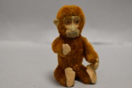 An early 20th century German Schuco monkey perfume or scent bottle having piccolo brown mohair