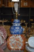 A modern Chinese styled lamp base with an antique Japanese Kutani ware folded rim dish having