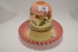An antique chamber stick or candle holder in custard glass with removable domed lid and decorated