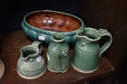 Three pieces of modern studio pottery in green glazes with a similar ceramic bowl