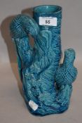 An antique Chinese porcelain vase having a azure blue glaze formed as a tree stem adorned with two