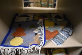 A vintage peg rug and similar woven Moroccan style rug with images of villagers and houses