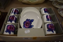 A boxed Wedgwood Susie Cooper design coffee canister and saucer set. Four saucers and six