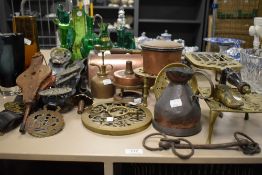 A collection of hardware including trivets, a small copper pan and horse brasses.