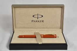 A boxed Parker Duofold International MKII converter fountain pen in orange with two bands to the cap