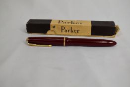 A Parker Junior Duofold fountain pen in red with decorative band to cap having Parker 10 nib in