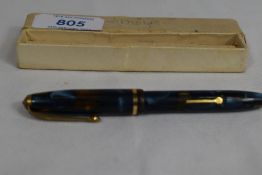 A boxed Conway Stewart Dinkie 550 lever fill fountain pen in blue brown marble with single band to