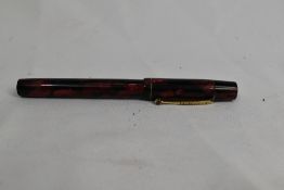 An Ingersoll lever fill fountain pen in red black marble with single narrow band to cap having