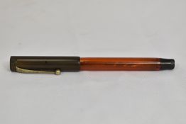 A Parker Lucky Curve Demonstrator button fill fountain pen in translucent amber bakelite with