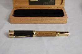 A hand turned roller pen in Bog Oak with clip in the form of a rifle and writing area in the shape