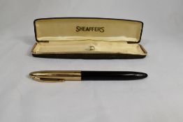 A boxed Sheaffer Snorkel fountain pen in black with gold cap with white spot, having Sheaffer 14k