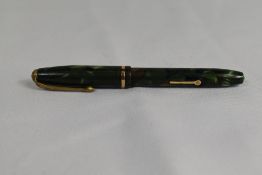A Conway Stewart Dinkie 550 lever fill fountain pen in green brown marble with single band to the