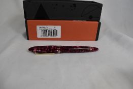 A Tibaldi Bononia Vintage Pomegranate piston fill fountain pen with three narrow bands to the cap