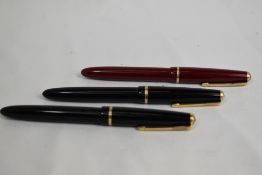 Three Parker Slimfold aeromatic fill fountain pens two in black one red, having decorative band to