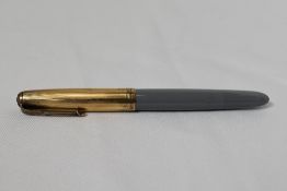A Parker 51 button fountain pen in grey with gold filled cap with blue diamond to the clip. In