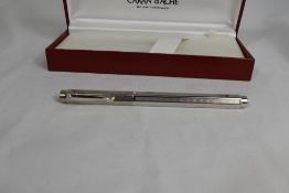 A boxed Caran d'Ache Ecridor rollerball pen. A hexagonal shaped, Rhodium plated pen with chevron