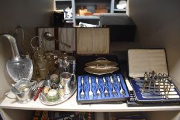An assortment of flat ware and similar, boxed cutlery sets, decanter and toast rack amongst this