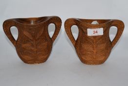 A pair of carved wood handled vases, having floral decoration.
