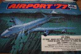 Two movie posters,' Airport 77' and 'Airplane II the sequel'.