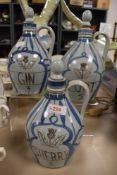 Three Scottish Buchan stoneware flagons, labelled for sherry, gin and port.
