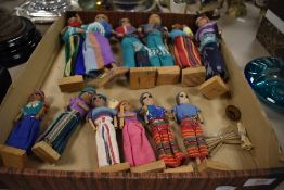 A collection of twelve ethnic dolls, in traditional styled clothes.