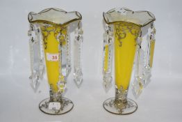 A pair of Victorian yellow glass table lustres, having clear drops, hand painted scroll decoration