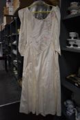 A circa 1988 wedding dress, having pink and silver embroidered detailing and bead work.