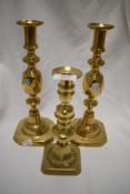 Three brass ejector candlesticks, two embossed with 'The Queen of Diamonds', with push lifters to
