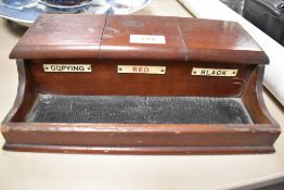 An early 20th century mahogany ink well holder with integrated pen tray.