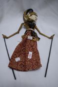 A decorative Indonesean puppet having carved wooden body and head with painted detailing.