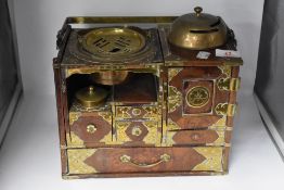 An early 20th century Chinese elm smokers cabinet, having decorative brass brackets, ash tray and