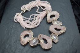 A 1980's oversized statement necklace by Butler & Wilson having seven pink agate panels in a white