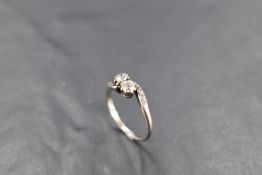 A two stone diamond ring, total approx 0.5ct to diamond chip set crossover shoulders on a white