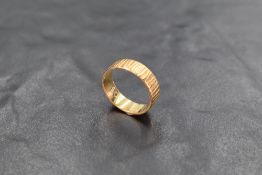 A yellow metal wedding band stamped 18ct, size K/L & approx 3.3g