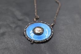 An early 20th Century silver and enamel pendant of circular form by Charles Horner having central